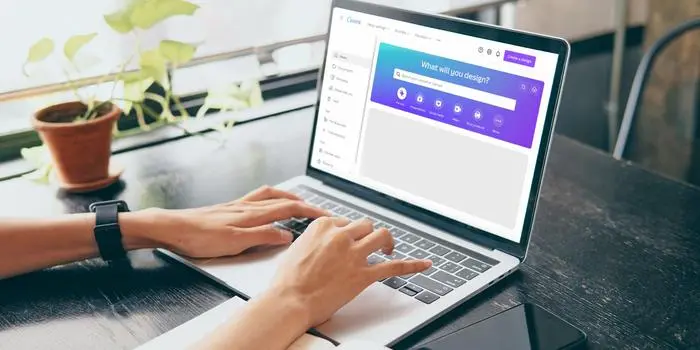 Laptop screen showing Canva dashboard with a person creating a digital product for sale
